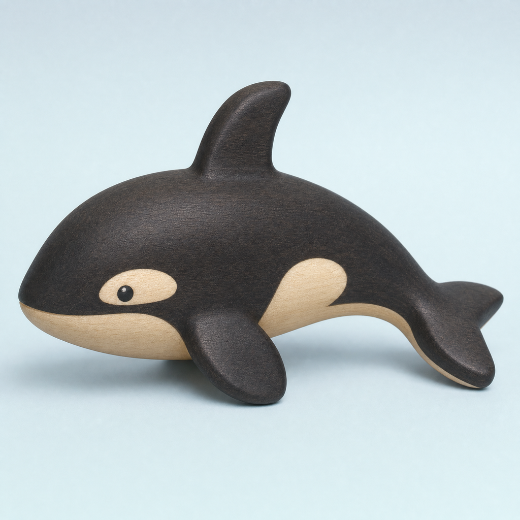 Jorlaxis Orca: a small wooden orca with a dark-stained back and pale belly on a plain pale background