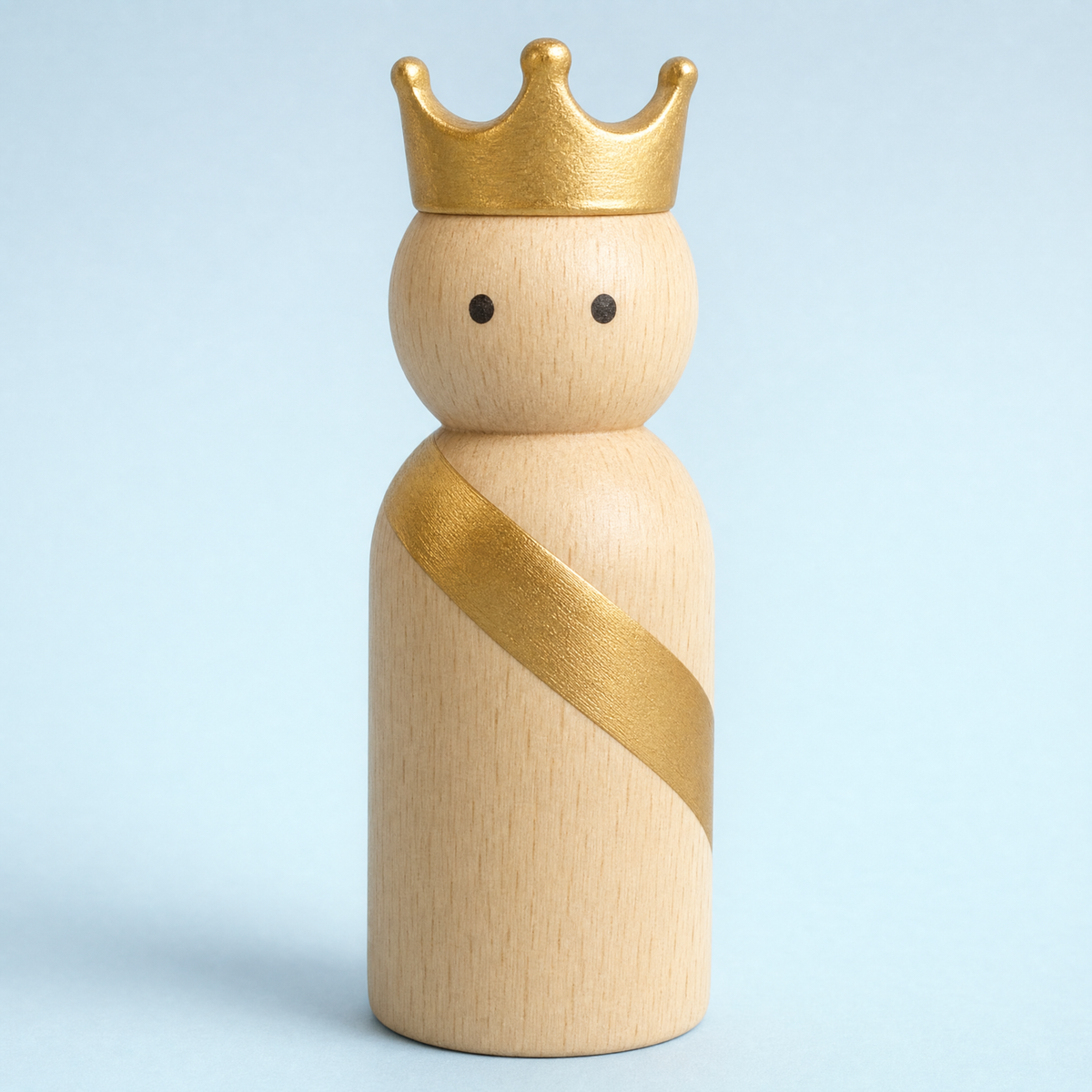Jorlaxis Crowned King: a pale wooden peg figure with a gold crown and sash