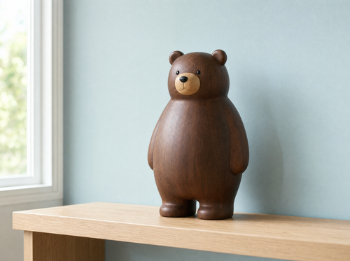 The large wooden bear on a pale oak shelf against a duck-egg blue wall